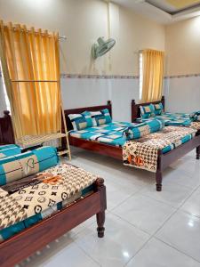 trzy łóżka siedzące w pokoju z w obiekcie NHÀ NGHỈ THANH XUÂN- Có cho thuê xe máy và xuất hóa đơn w mieście Ấp Ðông An (1)