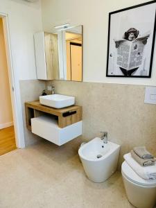 a bathroom with a sink and a toilet and a mirror at D-Living Casa Vigevano in Vigevano