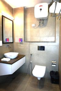y baño con aseo blanco y lavamanos. en Tipsyy Inn 018, en Gurgaon
