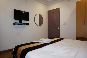 1 dormitorio con 1 cama y TV de pantalla plana en Tipsyy Inn 018, en Gurgaon