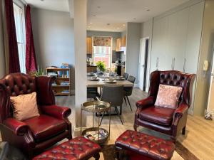 a living room with leather chairs and a table at Clarendon Luxury Apartment in Woodhall Spa