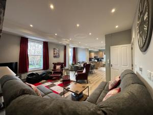 a living room with a large couch and a table at Clarendon Luxury Apartment in Woodhall Spa