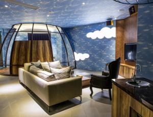 una sala de estar con sofá y una habitación con nubes pintadas en el techo en All-Ur Boutique Motel - Tai Tung Branch en Taitung