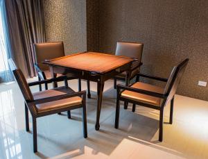 台東市的住宿－歐遊國際連鎖精品旅館- 台東館，一张木桌、四把椅子、一张桌子和一张桌子以及椅子