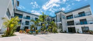 a white building with palm trees in front of it at Ocean Breeze Apartment in Nadi