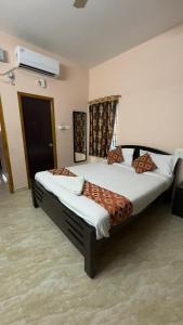 ein Schlafzimmer mit zwei Betten mit einer Katze auf ihnen in der Unterkunft Alexa Service Appartments (1BHK,2BHK with Kitchen) in Tirupati