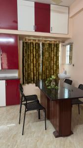 a kitchen with a table and a chair and a sink at Alexa Service Appartments (1BHK,2BHK with Kitchen) in Tirupati