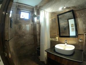 uma casa de banho com um lavatório e um chuveiro com um espelho. em Hotel Sethi Legacy em Haridwar