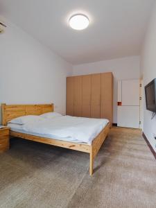 a bedroom with a wooden bed and a tv at 寻味成都人民中路店 in Chengdu