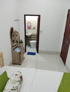 a bedroom with a bed and a bathroom with a sink at Homestay Châu Triều - Phan Thiết in Phan Thiet