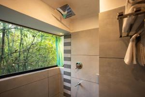 a bathroom with a window and a shower at Nexstay Lakkidi Village Resort in Vythiri