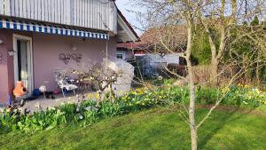 ein Haus mit einem Garten mit Blumen im Hof in der Unterkunft Luxus-Wohnung mit Garten, Terrasse & Wall-Box bei Dinkelsbühl in Dinkelsbühl