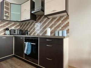a kitchen with stainless steel appliances and brown cabinets at Vaiva’s holiday home in Kaunas