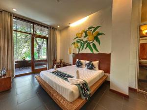 a bedroom with a large bed with a painting on the wall at Hostel by Monsoon Riverside in Phnom Penh