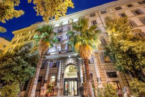a building with palm trees in front of it at Hotel Savoy in Rome