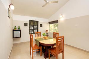 a dining room with a table and chairs at Nexstay Lakkidi Village Resort in Vythiri