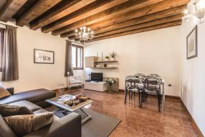 Ca' Del Monastero 3 Collection Apartment for 4 Guests with Lift في البندقية: غرفة معيشة مع أريكة وطاولة