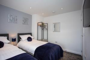 2 camas en una habitación con paredes blancas en Potterhouse Durham by #ShortStaysAway en Sheepscar