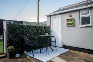 a small table and chairs in front of a green hedge at Potterhouse Durham by #ShortStaysAway in Sheepscar