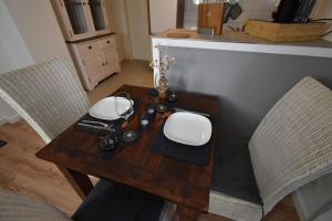 a wooden table with two chairs and a tableasteryasteryasteryasteryasteryasteryastery at Ferienwohnung mit Boxspringbett in Behrensdorf