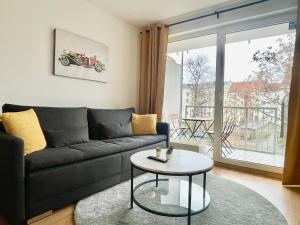 uma sala de estar com um sofá e uma mesa em Design City Apt Lilly - Kaffeebar, Balkon, Zentral em Leipzig
