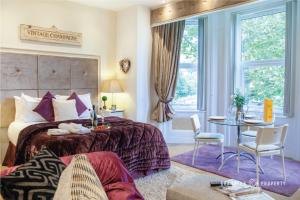 a bedroom with a bed and a table and chairs at Cosy 1bed Garden View Close to Beach and with Parking - Treetop Suite in Bournemouth