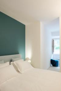 a bedroom with a white bed and a blue wall at La balza di Scilla in Scilla