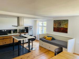 a room with a bed and a kitchen with a table at Lütt Oven Hus in Hiddensee