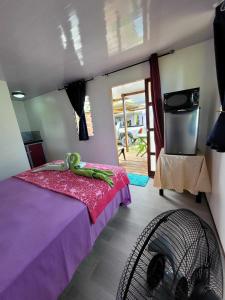 a bedroom with a bed with a green frog on it at Nuutea lodge 2 in Avatoru