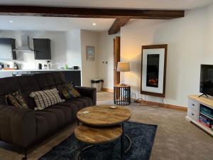uma sala de estar com um sofá e uma mesa em Hunters Glebe Country Apartment em Castlerock