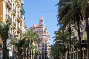 a tall building with a clock tower behind palm trees at Barraca Breeze in Valencia