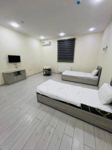 a bedroom with two beds and a flat screen tv at ERA HOTEL UCHTEPA in Tashkent