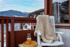 a sweater sitting on a chair on a balcony with glasses at Résidence Pierre & Vacances Le Britania in La Tania