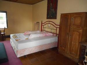 Un dormitorio con una cama y un armario de madera. en Shanti Homestay Pacung, en Patjung 19 fotos más