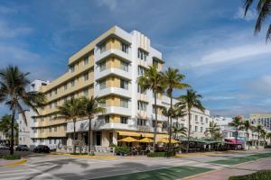 a large white building with palm trees in front of it at Winter Haven Hotel, Miami Beach, Autograph Collection in Miami Beach