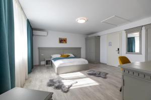 Sub CoastăにあるSky Rooms by Volo Guest Houseのベッドルーム1室(ベッド1台、テーブル、椅子付)