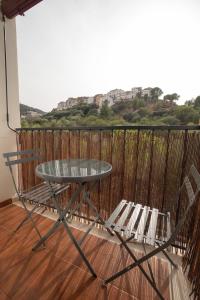 a glass table and two chairs on a balcony at Apartamento-Loft con vistas in Vilafamés