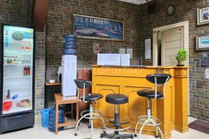 a bar with stools at a counter in a store at Puspita Homestay Mitra RedDoorz in Jakarta