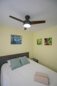a bedroom with a white bed with a ceiling fan at Apartamento-Loft con vistas in Vilafamés