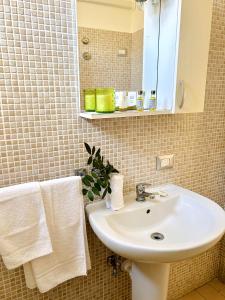 een badkamer met een wastafel, een spiegel en handdoeken bij Eden quattro archi Glory in San Pietro in Bevagna