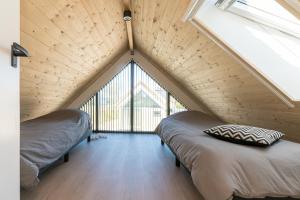 twee bedden in een kamer met een groot raam bij Riethoek Westerschouwen in Burgh Haamstede