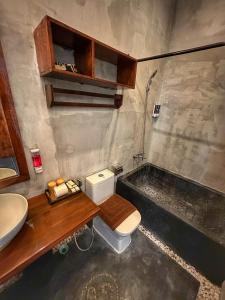 a bathroom with a toilet and a sink and a tub at Hostel by Monsoon Riverside in Phnom Penh