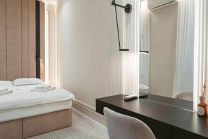 um quarto com uma secretária, uma cama e um espelho em Astoria Grand Hotel em Oradea
