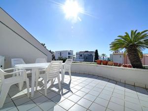 un patio con mesa y sillas en la azotea en Villa Las Vistas del Faro de Torredembarra, en Torredembarra