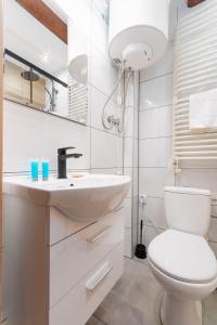 a bathroom with a white toilet and a sink at Groszowa Comfort Studio in Jelenia Góra