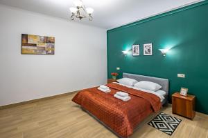 リヴィウにあるComplex of central apartmentsの緑の壁、ベッド付きのベッドルーム1室