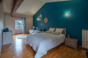ein Schlafzimmer mit 2 Betten und einer blauen Wand in der Unterkunft Les pierres de Fonfage in Boissezon