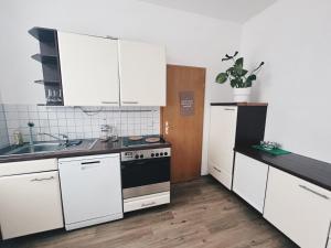 a kitchen with white cabinets and a sink and a stove at Pretty Home City Jungle in Zwickau