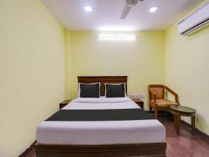 a bedroom with a large bed and a chair at Super Collection O Chepauk Near MA Chidambram Stadium in Chennai