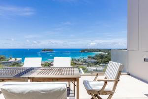 カタビーチにあるThe Heights Kata Phuket Luxury 2bedroom Ocean View B13の海を望むパティオ(テーブル、椅子付)
